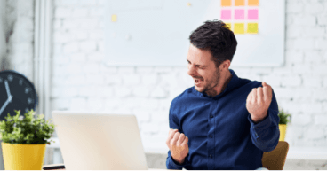 Man in front of a laptop Man in front of a computer shows a gesture of success